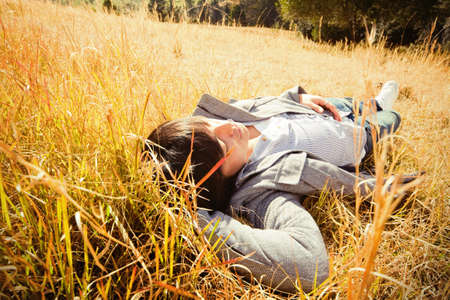 Young man rest on golden field.の写真素材