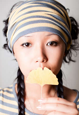 Close up shoot girl holding yellow leaf.の写真素材