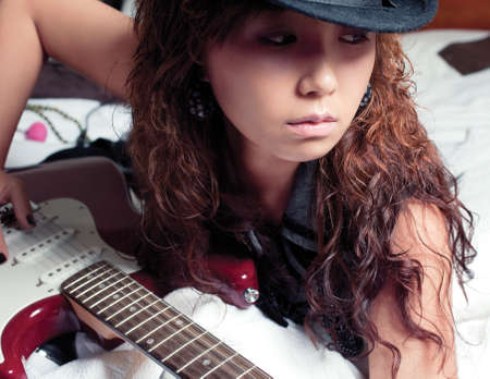 Young asian woman with a red guitar.の写真素材