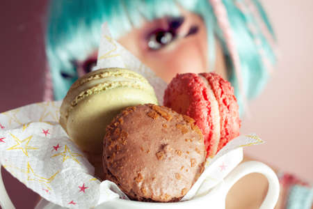 A young woman loves her sweet macaron.の写真素材