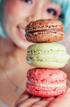 A young woman loves her sweet macaron.の写真素材