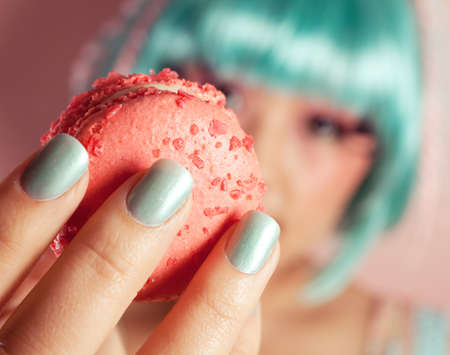 A young woman loves her sweet macaron.の写真素材