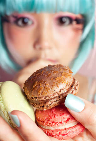 A young woman loves her sweet macaron.の写真素材