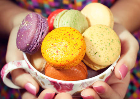 A young woman loves her sweet macaron.の写真素材