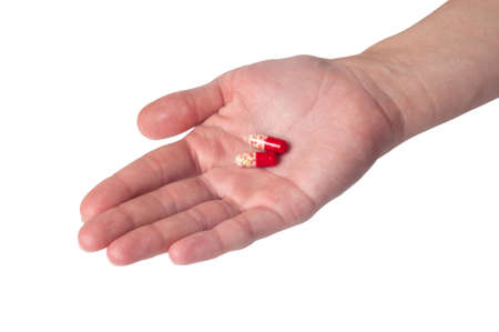 Pills in hand isolated on white backgroundの写真素材