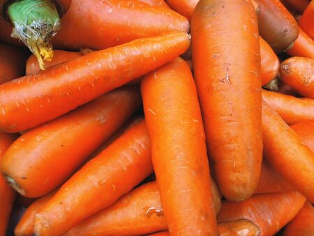 Beautiful, juicy, ripe fruits of carrots without tops, close-up in full screenの写真素材