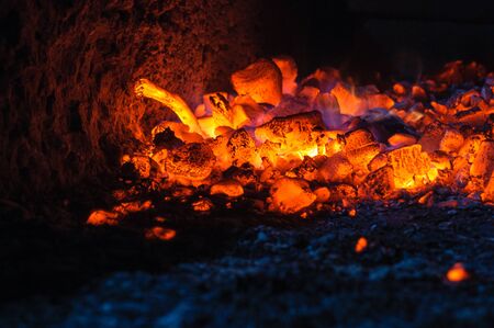Burning hot coals in a dying bonfireの写真素材