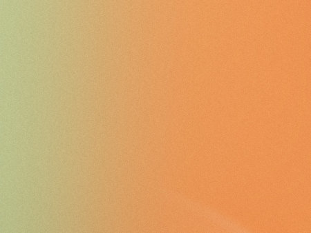 A gradient of colors blending from orange to green on a textured surfaceの写真素材