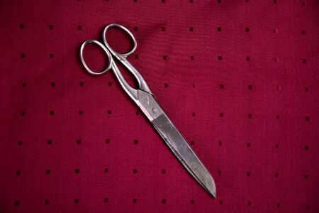 metal scissors red backgroundsの写真素材