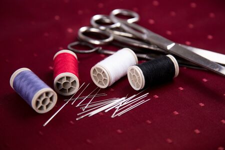 thread reel needle red background