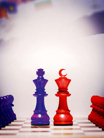 Two kings facing each other on the chessboard. The kings facing each other with cross and crescent signs. Photo manipulation. Pawns that follow in the back. 3d rendering.の写真素材