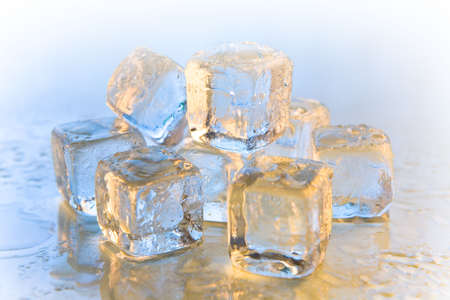 Melting ice cubes on reflective background