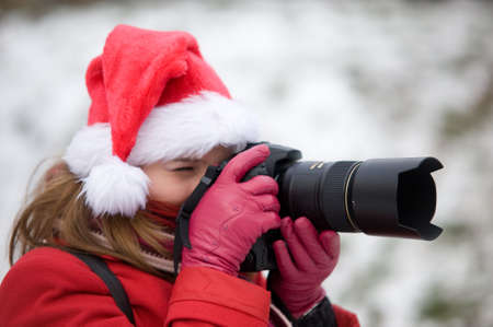 Christmas portrait of a woman with photo cameraの写真素材