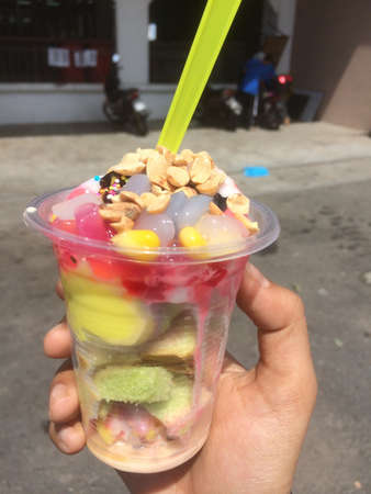 Songkhla ice cream with colourful bread, corn, peanut slices, glutinous rice, chocolate rice, chocolate syrup, sweetened condensed milk and coconut ice cream.の写真素材