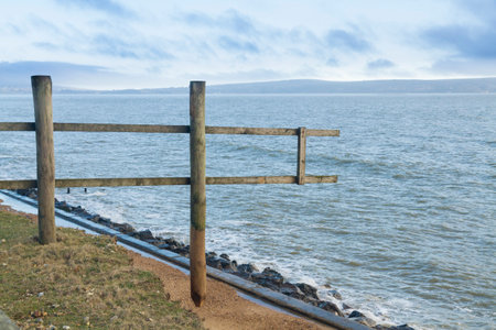 Wooden fence ending in mid-air over sea  After the February 14 2014 Valentineâs Day Storm, Milford on Sea, Hampshire, England, UKのeditorial素材
