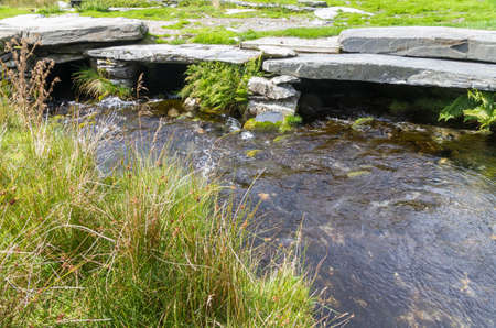 Water flowing below stone paved bridge.の写真素材