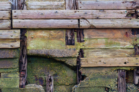 Detail of old pier, wooden planks weathered, crossing and decaying.の写真素材