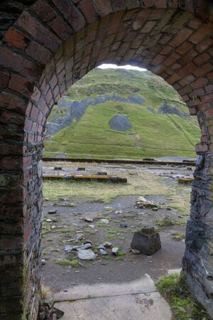 Looking through arch of ruin to valley of Cwmystwyth, remains of lead mining. Ceredigion, Wales, United Kingdom, Europe.の写真素材