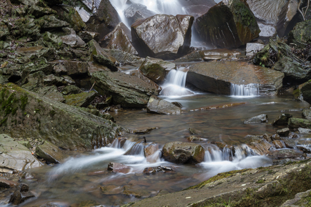 Detail of water cascading onto rocks at the bottom of a waterfall.の写真素材