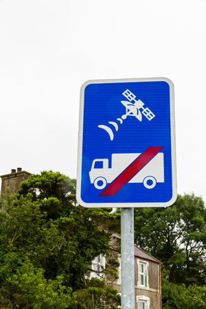 Blue sign showing lorry or HGV with red line through it and a satellite to warn that the road is unsuitable for lorries and not to trust sat-nav.の写真素材