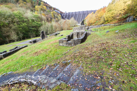 Ruins of Bryntail Lead Mine, the Clywedog Dam in the distance. Llanidloes, Powys, Wales, United Kingdom.の写真素材