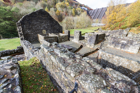 Ruins of Bryntail Lead Mine, the Clywedog Dam in the distance. Llanidloes, Powys, Wales, United Kingdom.の写真素材