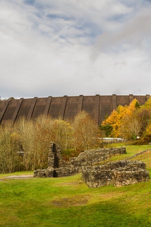 Ruins of Bryntail Lead Mine, the Clywedog Dam in the distance. Llanidloes, Powys, Wales, United Kingdom.の写真素材