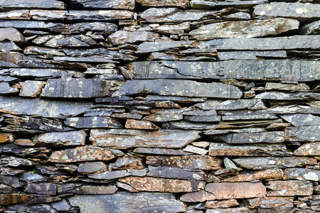 Old weathered dry stone slate wall making background textureの写真素材