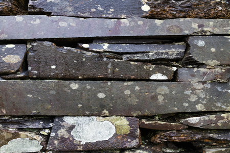 Old weathered dry stone slate wall making background textureの写真素材