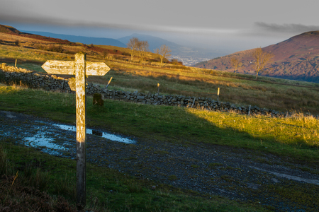 Finger sign post catching the last ray of sun at sunset.  To Pwll Du, Gilwern Hill and Tyla. Blorenge, Abergavenny, Wales, United Kingdom.の写真素材