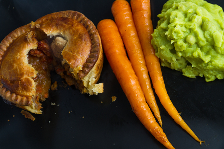 Quality chicken pie served with freshly squeezed orange glazed carrots and mushy peas.の写真素材
