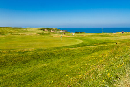 MORFA NEFYN â JUNE 3: Golf course putting green with golfers, sea in background, June 3, 2016 in Morfa Nefyn.のeditorial素材