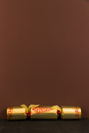 Gold Christmas cracker with brown space above it.の写真素材