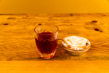 Shot glass with slow gin and mince pie, on wooden table.の写真素材