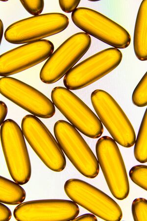 Close up of fish oil capsules on white tablet background.の写真素材