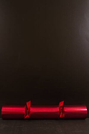 Red Christmas cracker with black space above it.の写真素材