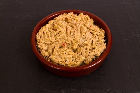Homemade smoked mackerel pate in a ceramic disk on a slate background.の写真素材