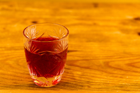 Shot glass with slow gin, on wooden table.の写真素材