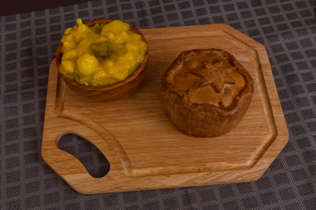 Piccalilli relish in a wooden bowl on a board.の写真素材