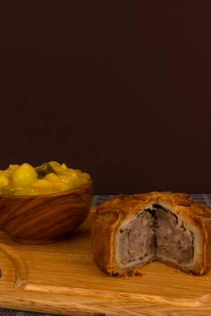 Piccalilli relish in a wooden bowl on a board.の写真素材