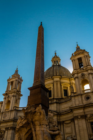 Basilica of Sant Agnese in Agone in the Piazza Navona with Egyptian Obelisk in the foreground and afternoon sun behind church. Rome in Italy.のeditorial素材