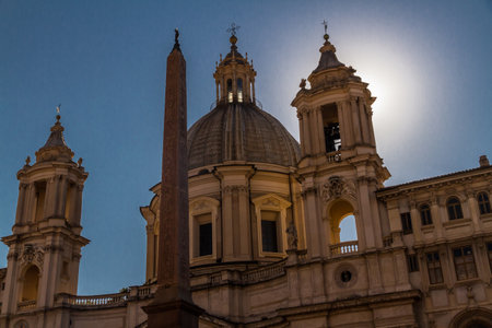 Basilica of Sant Agnese in Agone in the Piazza Navona with Egyptian Obelisk in the foreground and afternoon sun behind church. Rome in Italy.のeditorial素材