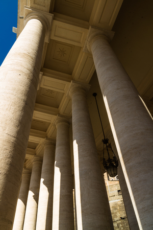 Looking up at Colonnades in St Peters Square, Vatican, Rome. Including daylight half moon.の写真素材