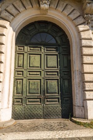 Faded green door with paint peeling sunlight and shadeの写真素材