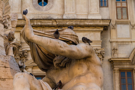 Part of a statue of the Fontana dei Quattro Fiumi fountain with pigeons. Piazza Navona, Rome in Italyのeditorial素材
