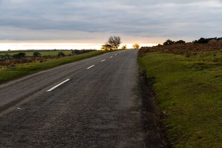 Small UK country road looking towards west at sunset.の写真素材