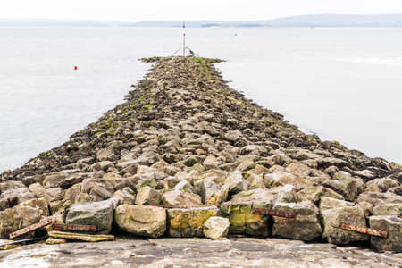 Stone Breakwater at Burry Port Harbour, Llanelli, Carmarthenshire, Wales.の写真素材
