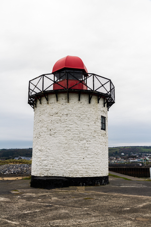 Small white squat white lighthouse with red top. Burry Port, Llanelli, Carmarthenshire, Wales.の写真素材