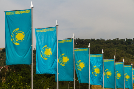 Line of blue and yellow Kazakh flags in wind, Almaty, Kazakhstan, Asia.の写真素材
