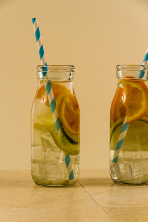 Childrens water drinks in bottles with straw. Slices of orange, lemon and lime.の写真素材